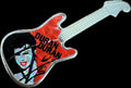 Metallic guitar-shaped pin printed with 'Duran Duran' and an image of a woman's face.
