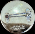 Back view of a silver pin with 'Made in England' engraving on a metallic surface.